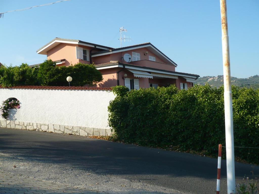 una casa sul lato di una strada con un muro bianco di Azienda Agrituristica Villa Arianna a Imperia