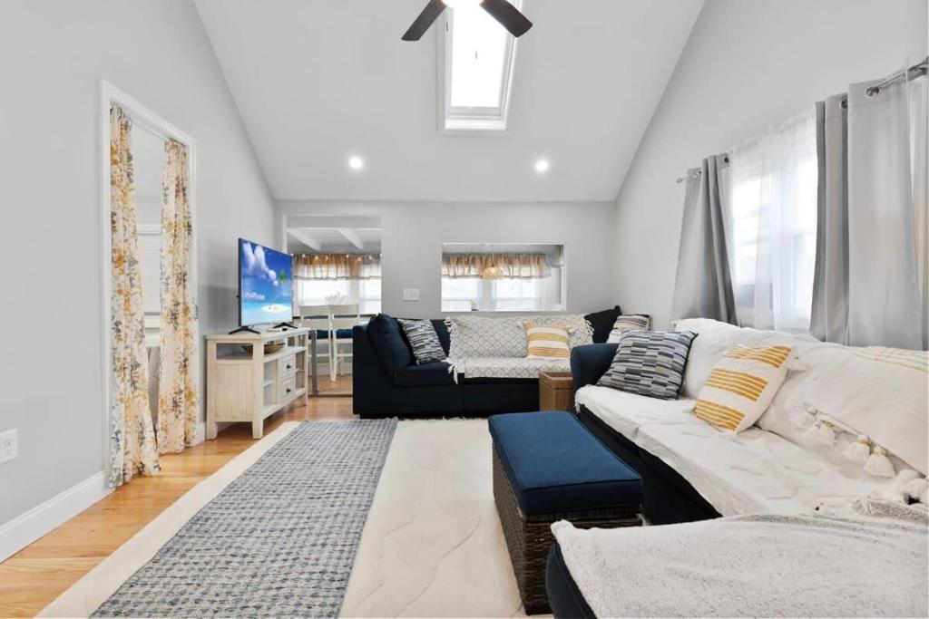 a living room with a couch and a tv at Newly Renovated Beachside Bliss Steps to Sand in Salisbury