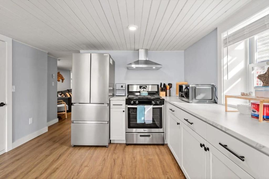 a kitchen with stainless steel appliances and white cabinets at The Addie Shack Pet Friendly Steps to Beach in Salisbury