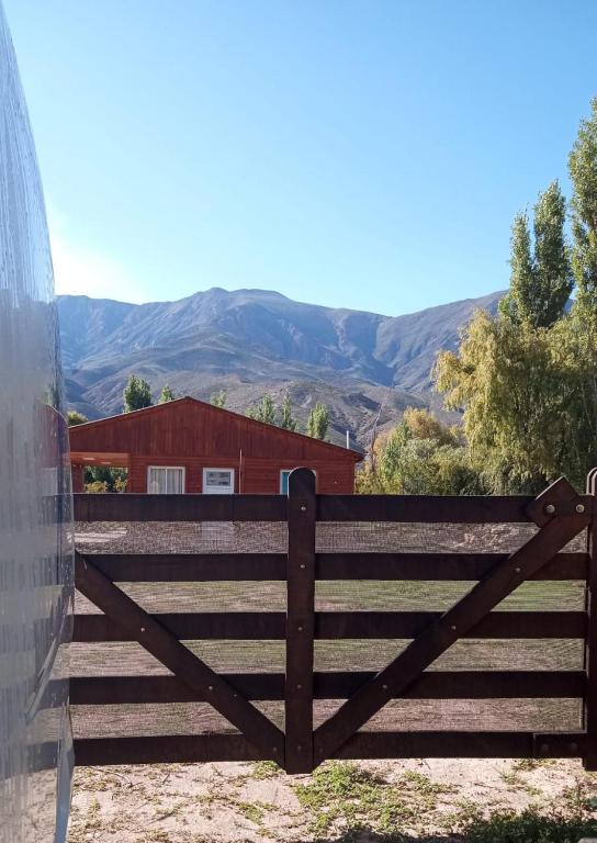 a wooden gate with mountains in the background at La Cabaña hospedaje in Tilcara