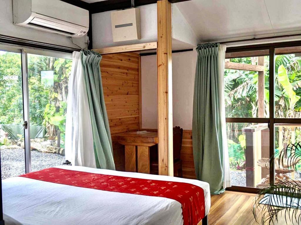 奄美市にあるFamily house プール付オーシャンビュー Amami "Birdland Nature Resort"のベッドルーム1室(ベッド1台、大きな窓付)