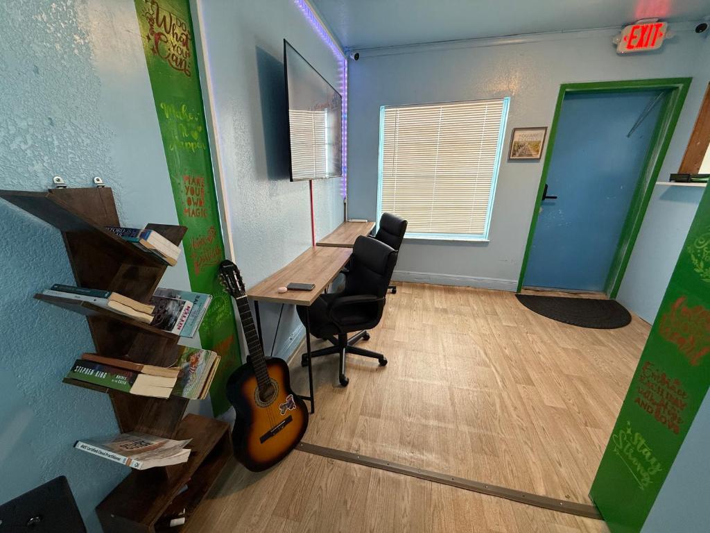 an office with a desk and a guitar in a room at OQP Vacations in Miami