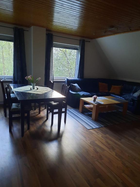 a living room with a table and a couch at Ferienwohnungen an der Schusteracht Dachgeschoss und Souterrain in Kiel