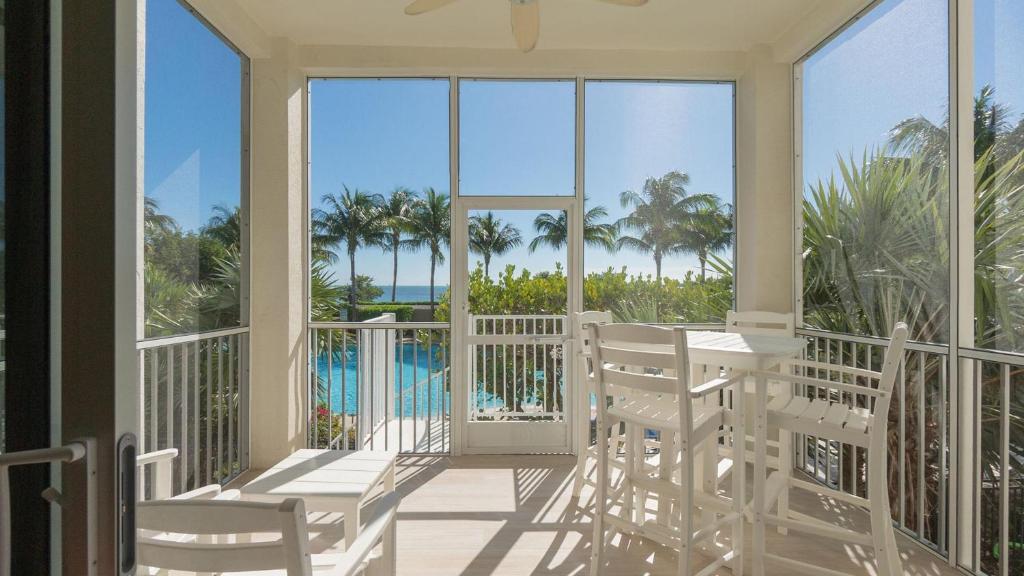 a balcony with white chairs and a view of the ocean at 408 Mariners Club in Key Largo