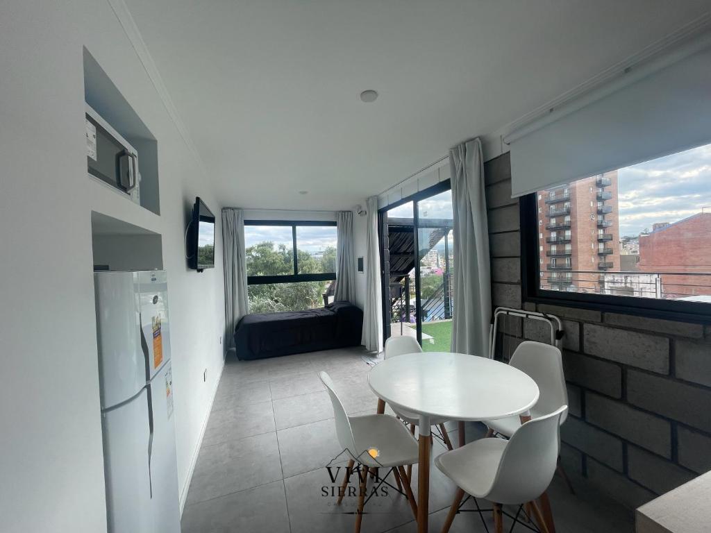 a kitchen with a white table and chairs in a room at Vivisierras, Piso 4 frente al lago Centro Villa Carlos Paz, pileta privada, vista panorámica in Villa Carlos Paz