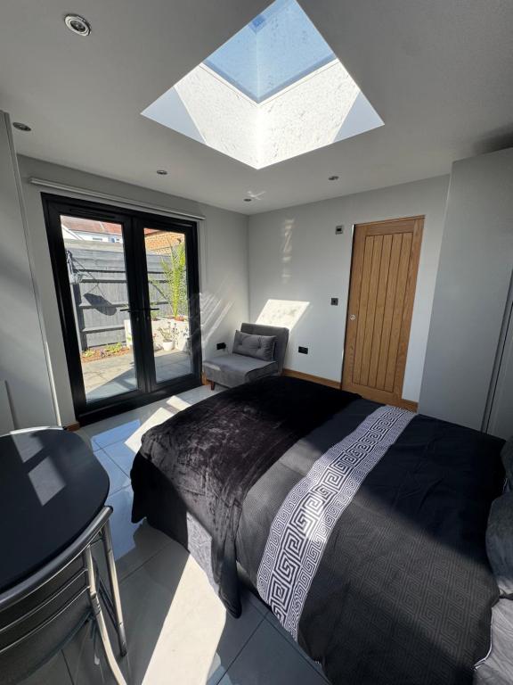 a bedroom with a large bed and a skylight at Contemporary garden studio in Brighton! in Brighton & Hove