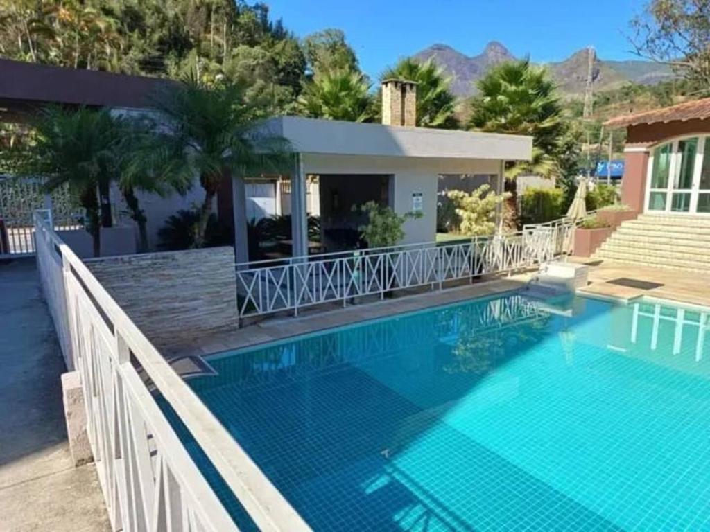 a swimming pool in front of a house at Charme da Serra Ape Aconchegante em Correas in Petrópolis