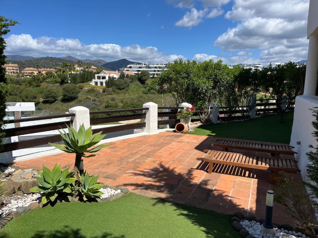 patio z drewnianą ławką na podwórku w obiekcie Luxurious and spacious apartment with a private garden and solarium with great views in Estepona área Marbella La Resina Country Golf w mieście Estepona