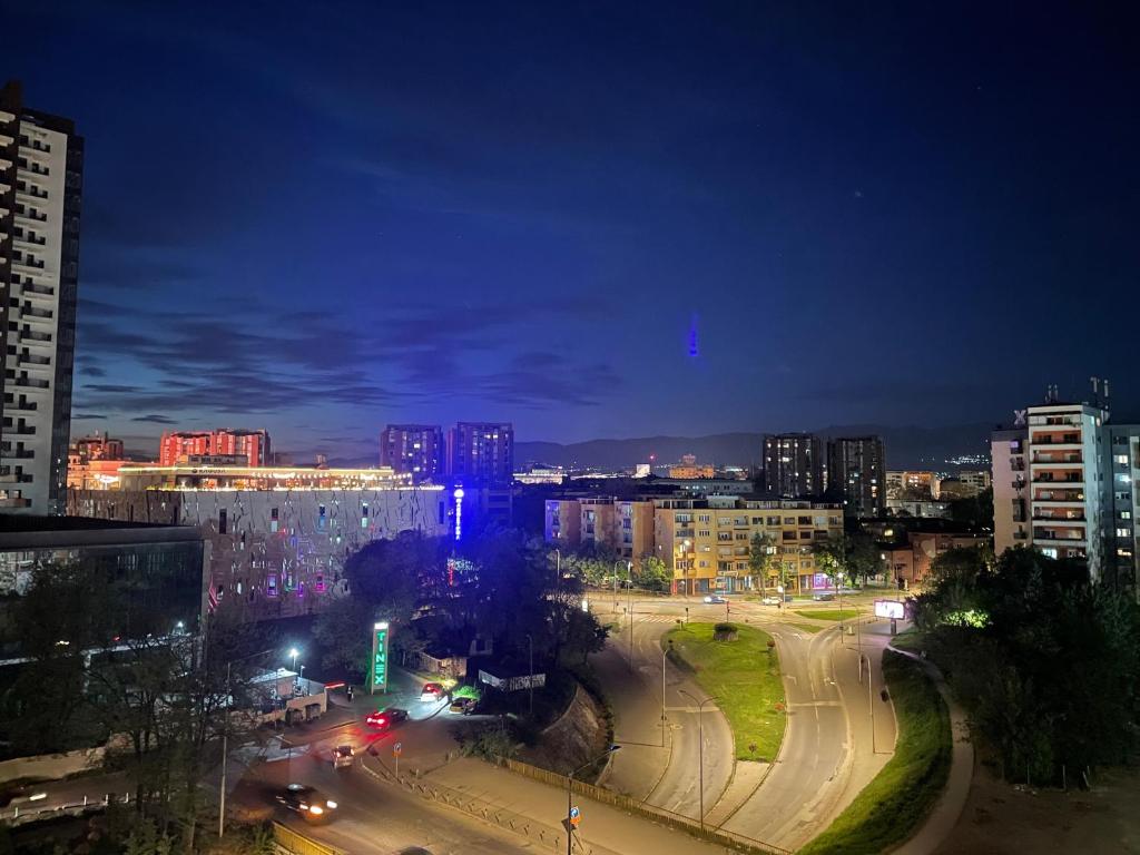 una città illuminata di notte con le auto su una strada di City Center Gem a Skopje