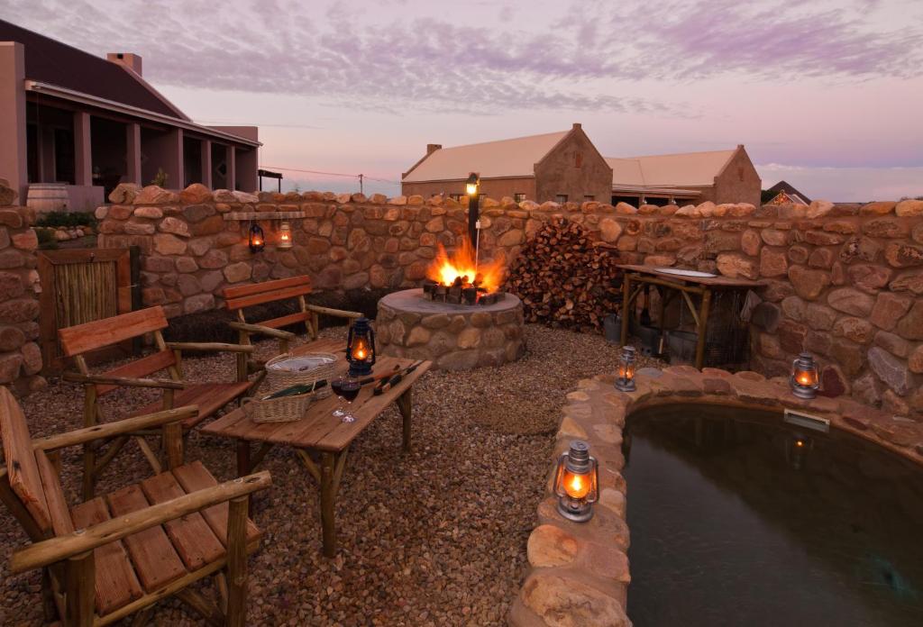 einen Hinterhof mit einem Pool und einer Feuerstelle in der Unterkunft Karoo View Cottages in Prince Albert