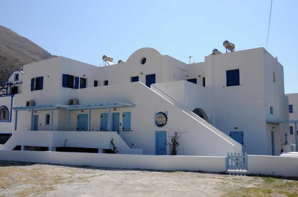 a white building with blue doors and windows at Adelphi Apartments in Perissa