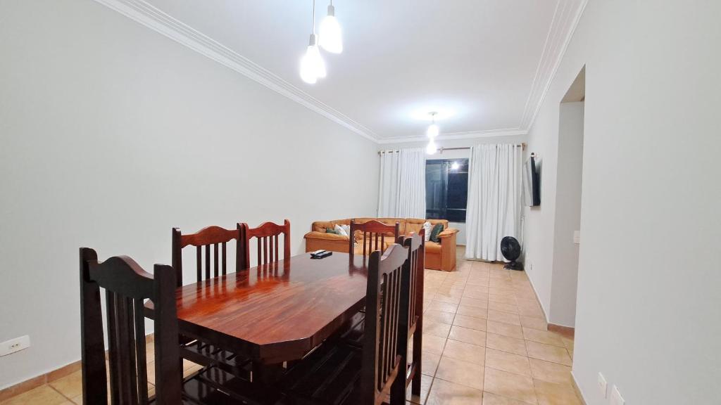 a dining room with a table and a couch at Pitangueiras Pé na Areia in Guarujá