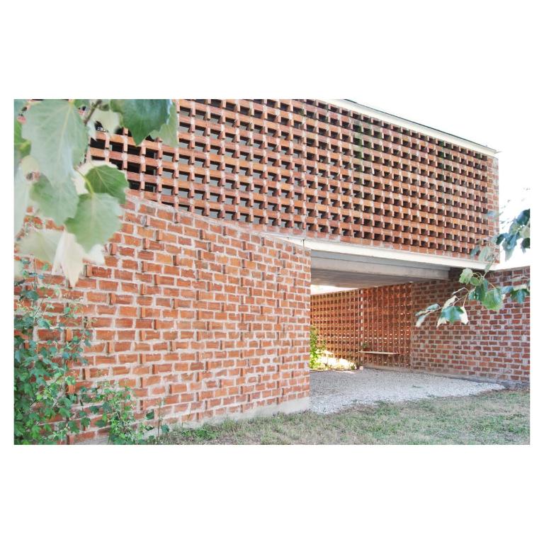 a red brick wall with a patio in front of it at Casa PDS in La Porteña