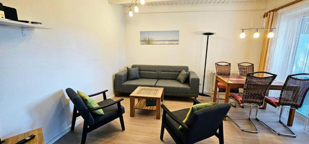 a living room with a couch and chairs and a table at Haushaelfte-Hein-105 in Böhl