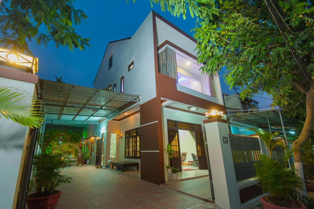 a house with a facade with trees in front of it at Royal Homestay in Hoi An