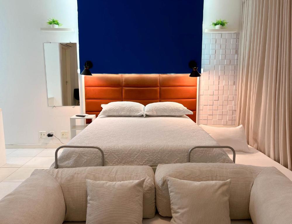 a bedroom with a large bed with a blue wall at Flat particular no hotel Fusion in Brasilia