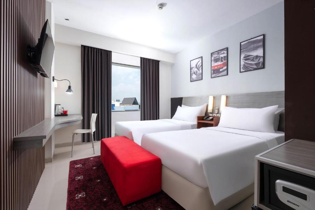 Postel nebo postele na pokoji v ubytování Hotel Neo Candi Simpang Lima - Semarang by ASTON