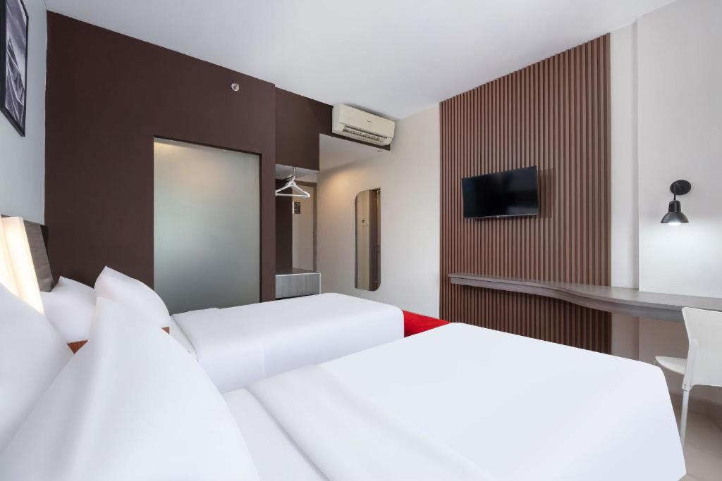 Postel nebo postele na pokoji v ubytování Hotel Neo Candi Simpang Lima - Semarang by ASTON