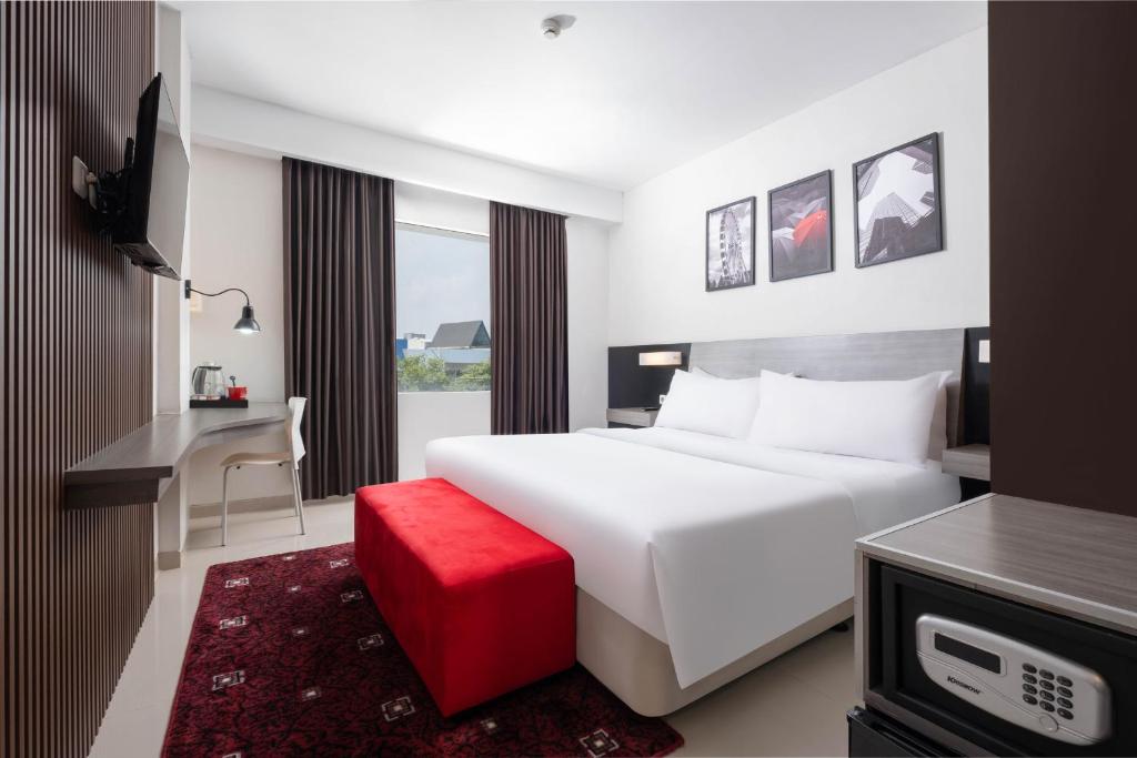 Postel nebo postele na pokoji v ubytování Hotel Neo Candi Simpang Lima - Semarang by ASTON