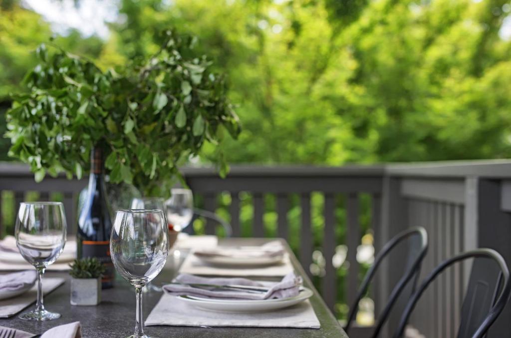 un tavolo con due bicchieri da vino e una pianta in vaso di Gracemont Boutique Accommodation a Healesville