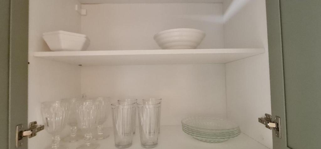 a white cabinet with glass vases and plates on it at Spazzio 631 Diroma COM CLUBE GRATIS TODO DIA in Caldas Novas