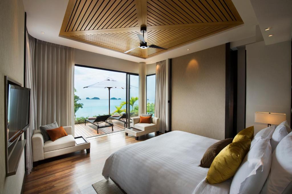 Conrad Koh Samui في شاطئ تالينغْنام: غرفة نوم بسرير وتلفزيون وفناء