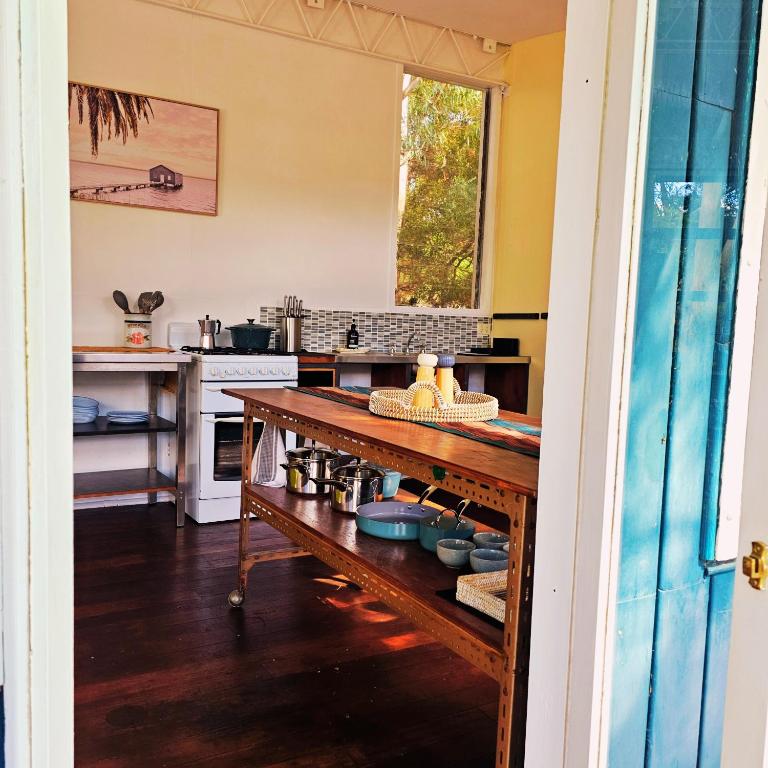 una cucina con tavolo al centro di Sunrise Cottage 'Guildford VIC' a Guildford