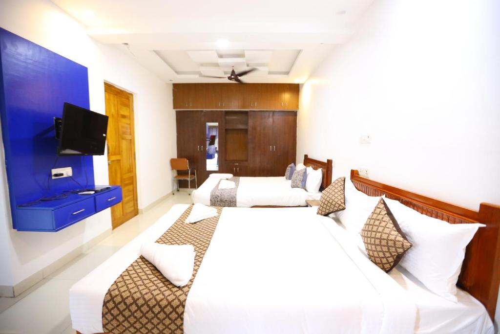 a hotel room with two beds and a flat screen tv at Hotel Starlight Chennai near DLF,L&T,Miot,Tradecenter,Ramachandra medical coll in Chennai