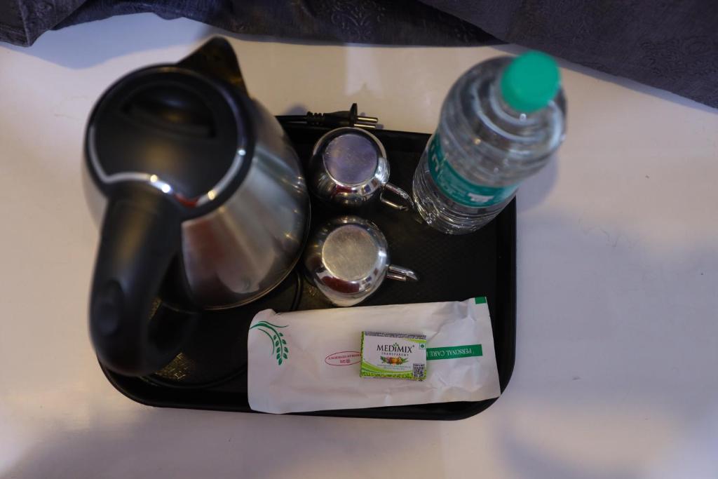 a tray with a tea kettle and a bottle of water at Hotel Starlight Chennai near DLF,L&T,Miot,Tradecenter,Ramachandra medical coll in Chennai