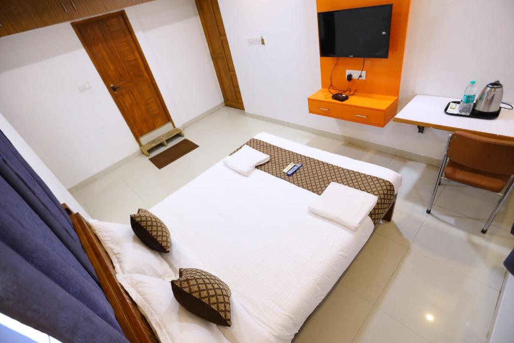 a room with a bed and a desk and a tv at Hotel Starlight Chennai near DLF,L&T,Miot,Tradecenter,Ramachandra medical coll in Chennai