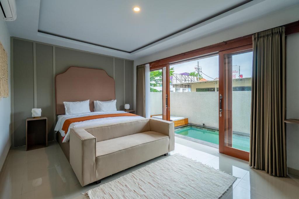 a bedroom with a bed and a chair and a pool at Villa Latsu Canggu in Canggu