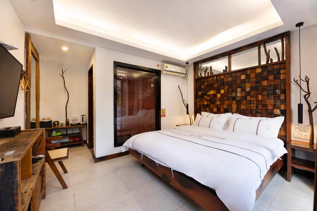 um quarto com uma cama grande e uma janela grande em Xitang Overnight Garden B&B em Jiaxing