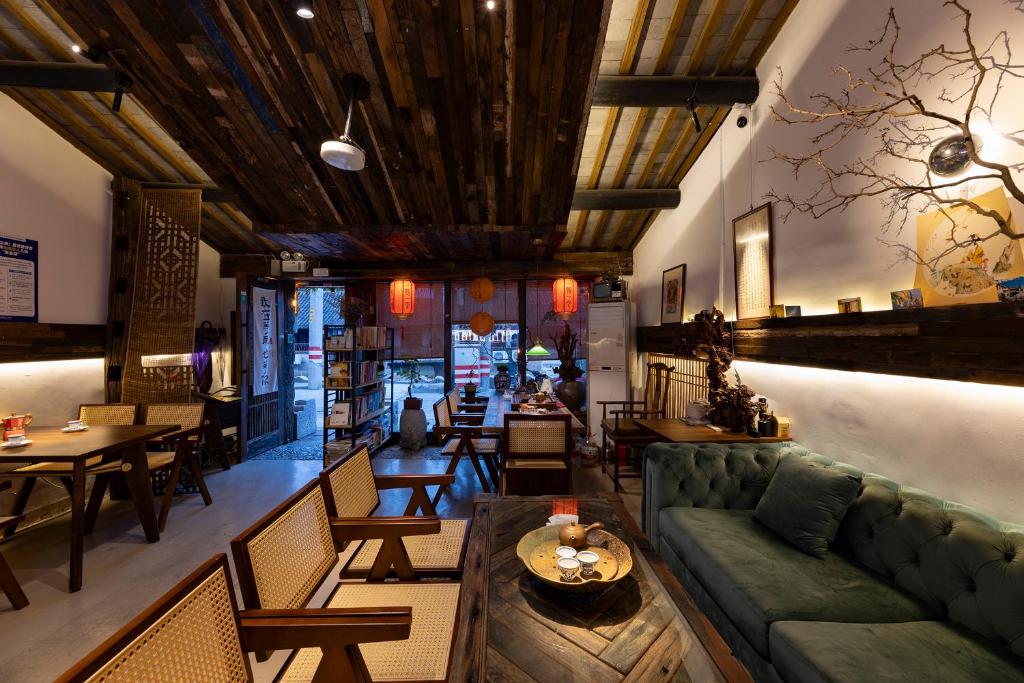 um restaurante com um sofá, mesas e cadeiras em Xitang Overnight Garden B&B em Jiaxing