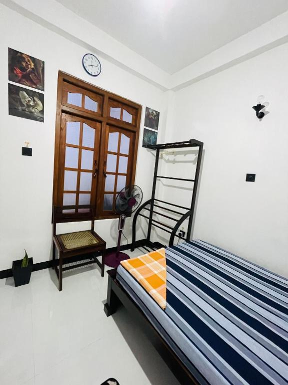 a bedroom with a bed and a clock on the wall at Suriya Haven Homestay in Badulla