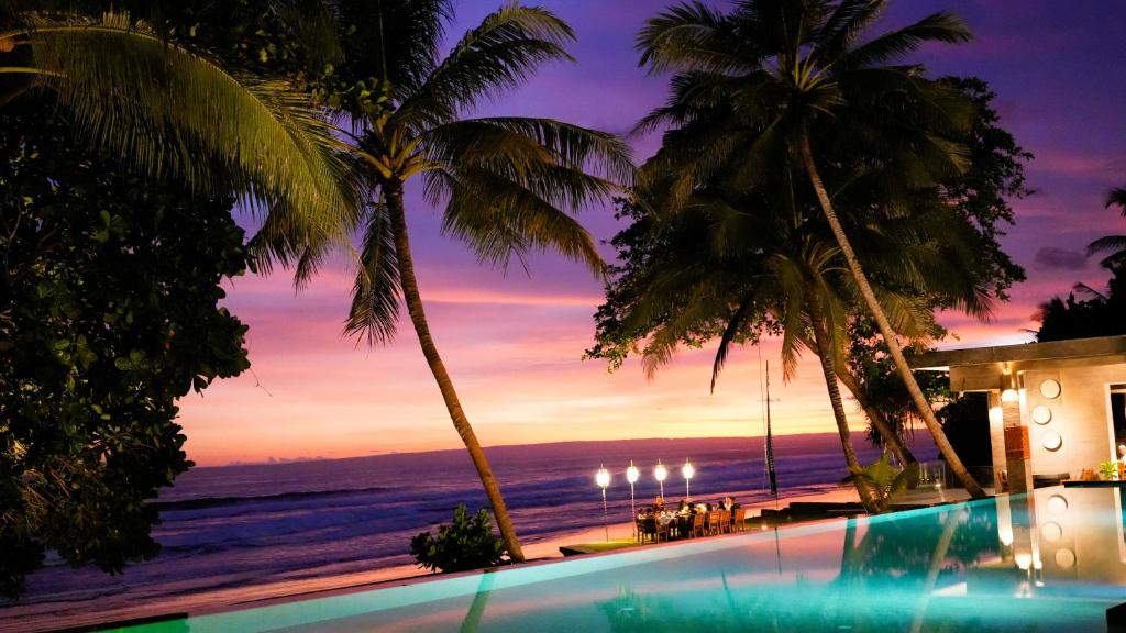a swimming pool with a view of the ocean at Kelapa Retreat & Spa in Pulukan