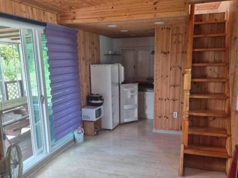 une pièce avec une cuisine avec un réfrigérateur et un escalier dans l'établissement Cheongdo Provence Light Festival Caravan Pension, à Cheongdo