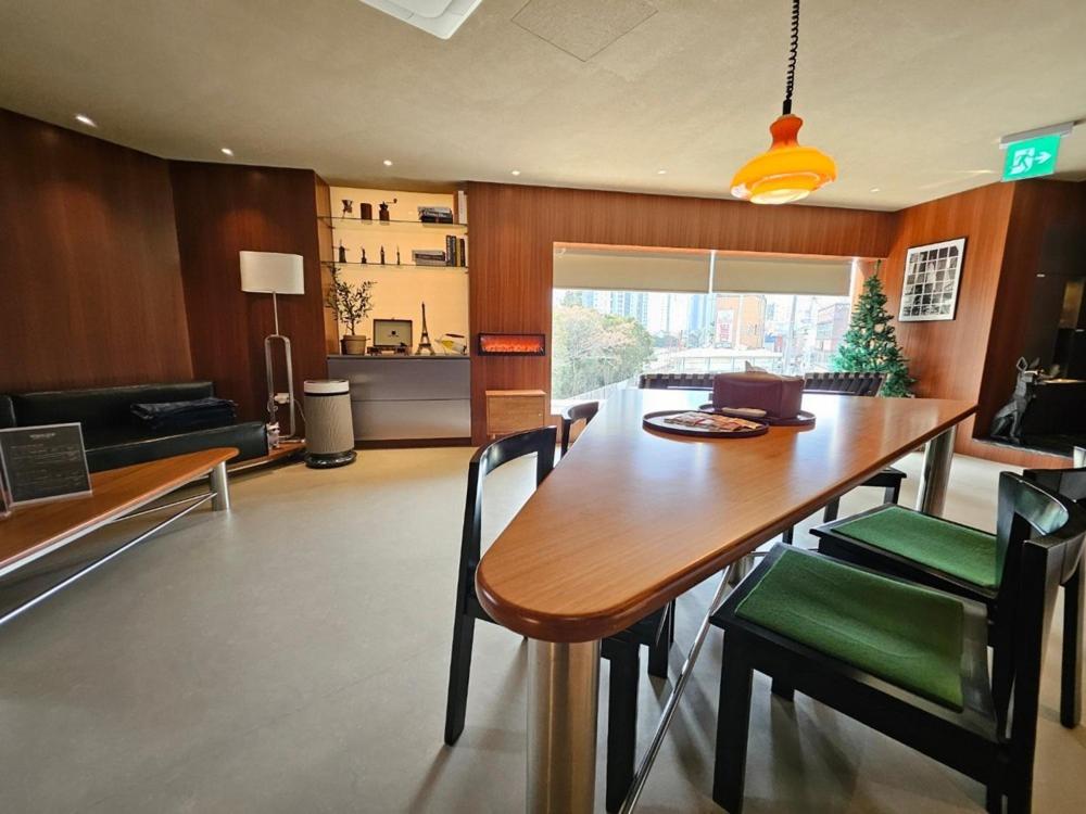 a dining room with a large wooden table and chairs at Private House Guten Morgen Haeundae Main Branch in Busan