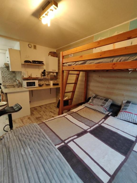 une chambre avec deux lits superposés et une cuisine dans l'établissement Studio à Super Besse, à Besse-et-Saint-Anastaise