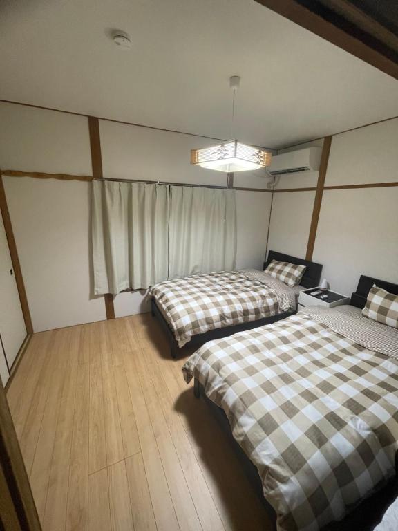 a bedroom with two beds and a window at 福苑李 in Osaka
