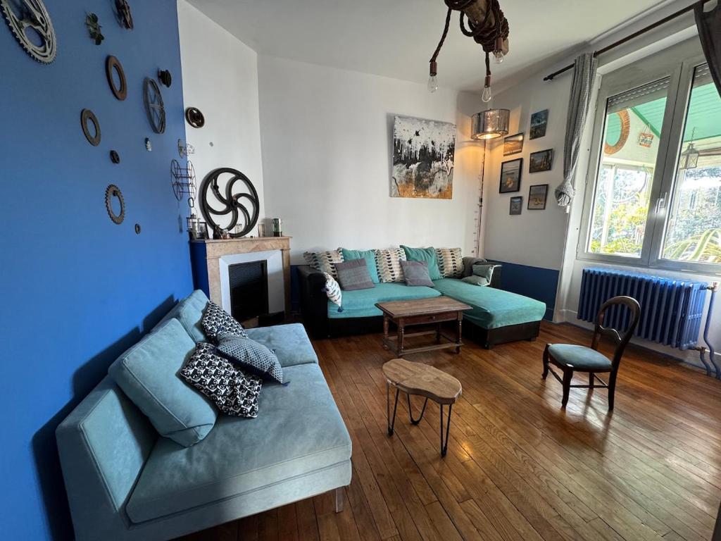 un salon avec un canapé bleu et une table dans l'établissement Colorful 1930s house, à Portes-lès-Valence