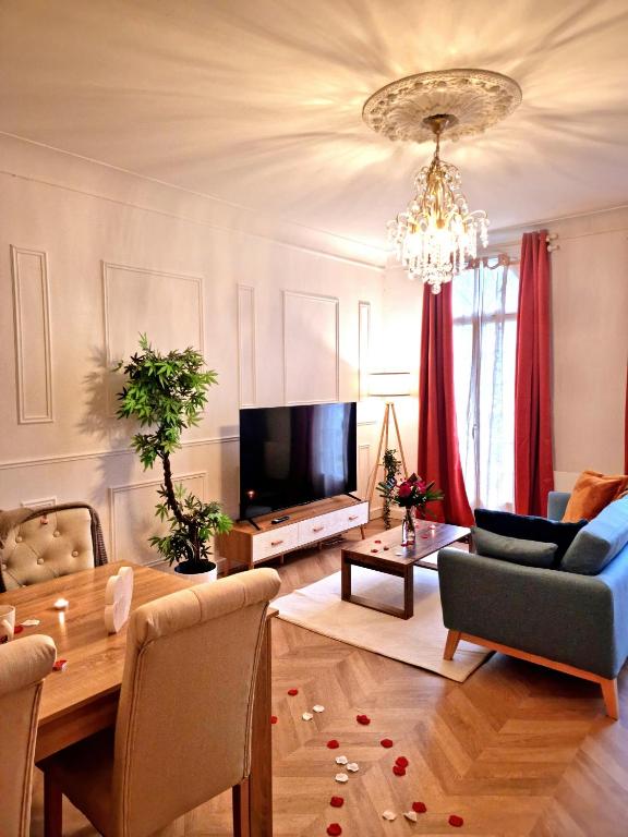 un salon avec une table et une télévision dans l'établissement Le Classique, à Montpon-Ménestérol