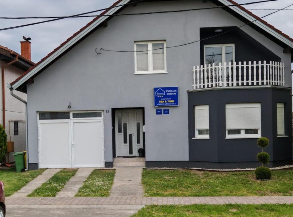 a white and black house with a garage at Apartmani Tea i Toni in Gradište