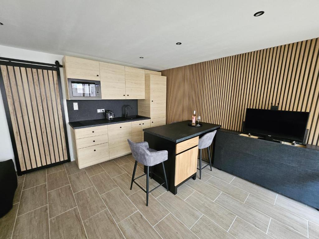 une cuisine avec un comptoir, une table et des chaises dans l'établissement Studio chic climatisé avec vue mer et piscine à 100m plage du Môle, au Cap d'Agde