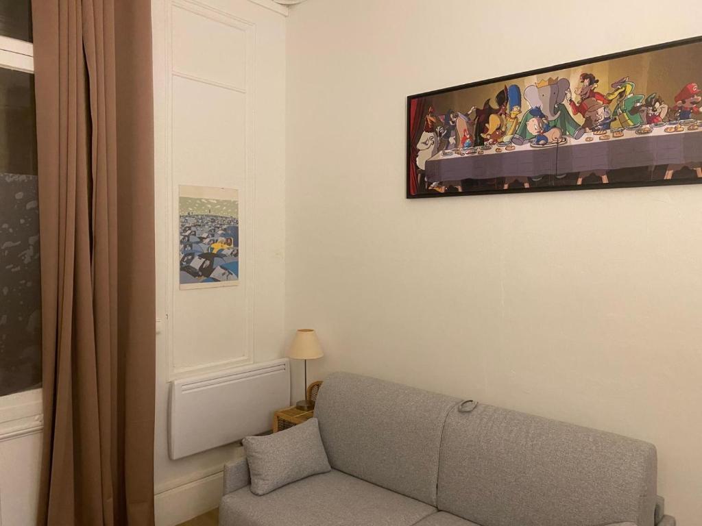 un salon avec un canapé et un tableau au mur dans l'établissement Loge, Studio facing Gare du Nord, à Paris