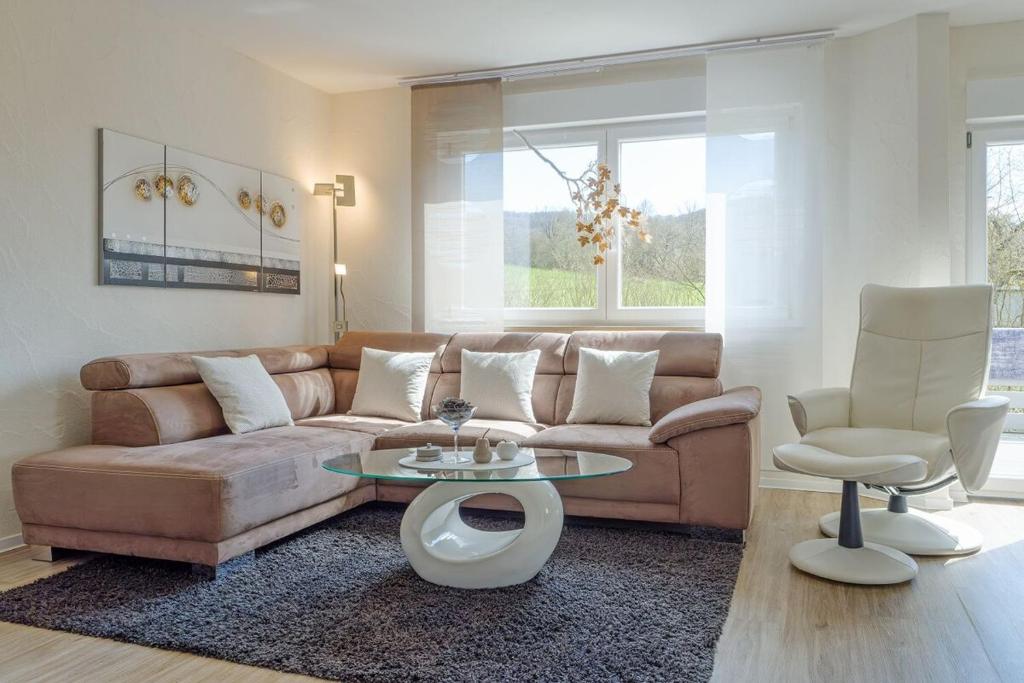 sala de estar con sofá, mesa y 2 sillas en Ferienhaus am Rennweg, en Leinach