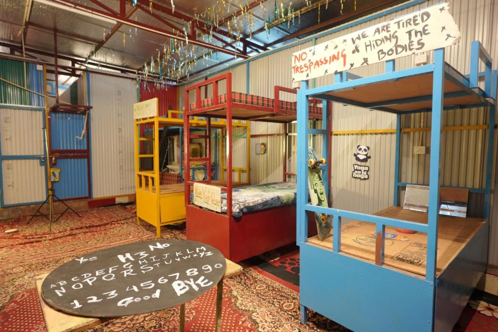 une chambre avec deux lits superposés et une table dans l'établissement Happy Hippy Hub by Yatrimap, à Jāmb