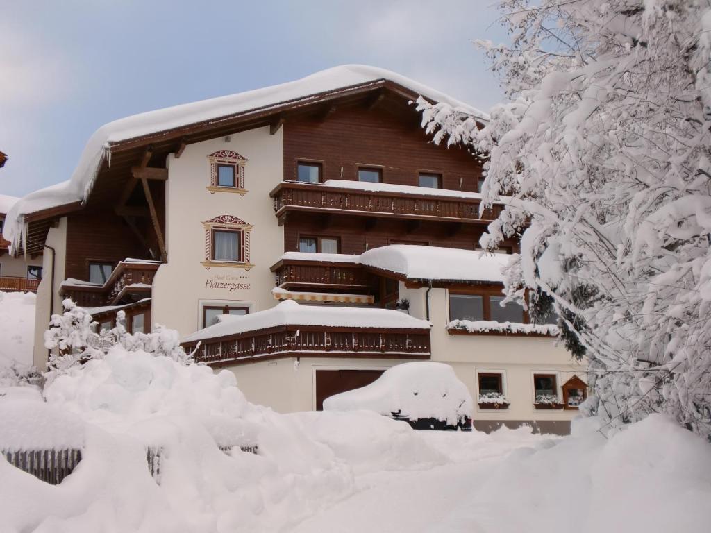 a building covered in snow with snow covered trees at Hotel Appartement Platzergasse in Fiss