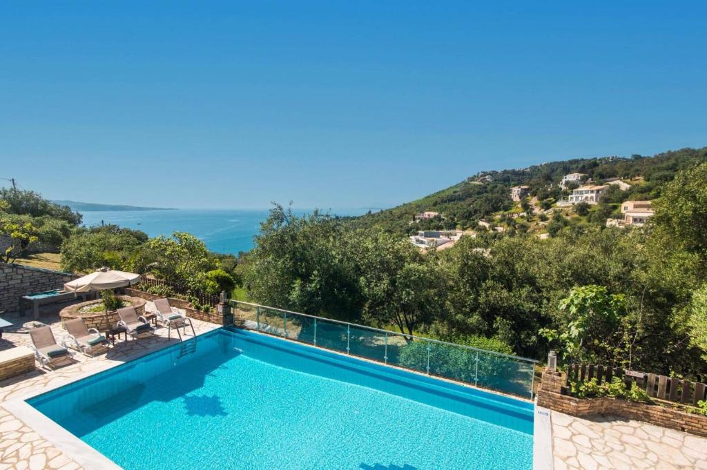 a villa with a swimming pool and a mountain at Villa Adonis by Villa Plus in Agnítsini
