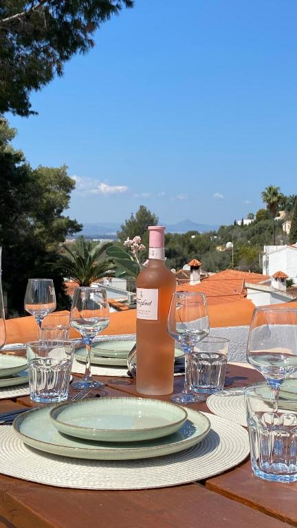 a table with a bottle of wine and glasses on it at Casa el Montcel, a unique chalet with roofterrace and shared pool in Denia