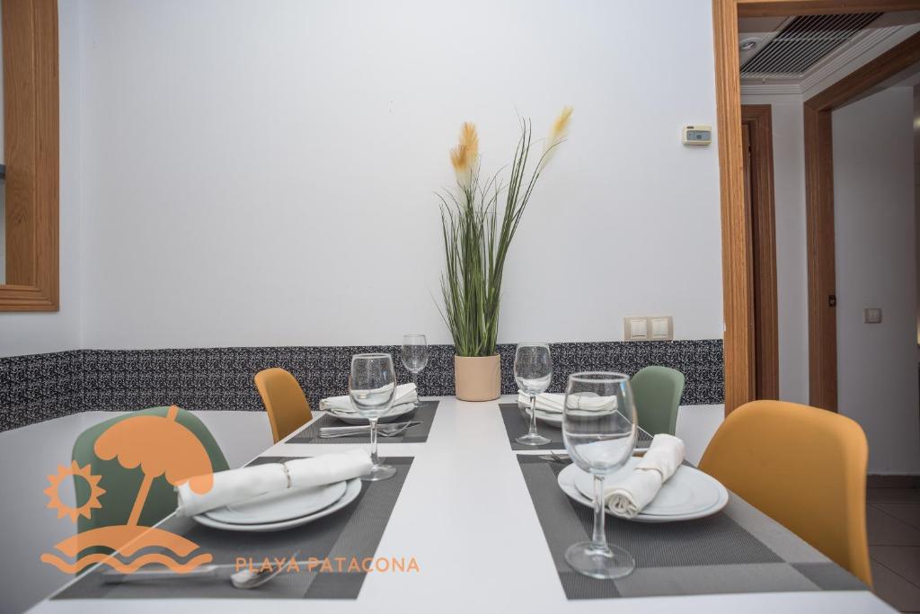 a dining room table with wine glasses and chairs at Patacona Resort Apartments Primera Linea in Valencia